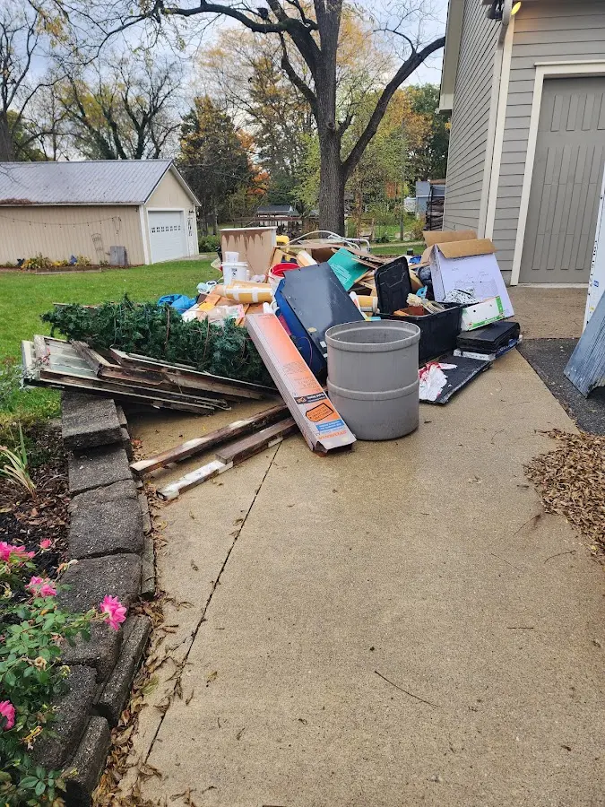Dumpster being loaded with debris for 12 Yard Dumpster Rental in Olivette